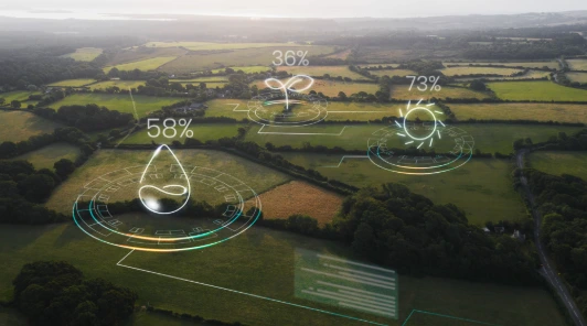 Imagem aérea de lavouras com indicadores digitais de monitoramento, representando o uso de IA, IoT e agricultura de precisão no agronegócio.